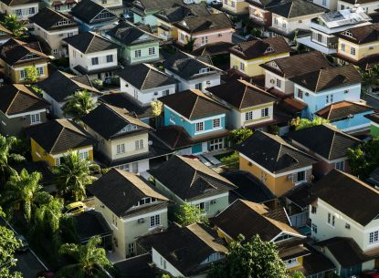Aerial view of a colourful suburban neighbourhood with modern houses and lush greenery