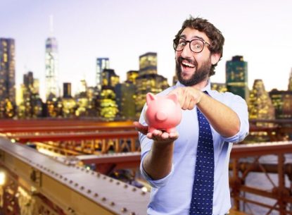 Man in glasses holding piggy bank in front of city skyline, wearing blue tie and white shirt, savings concept